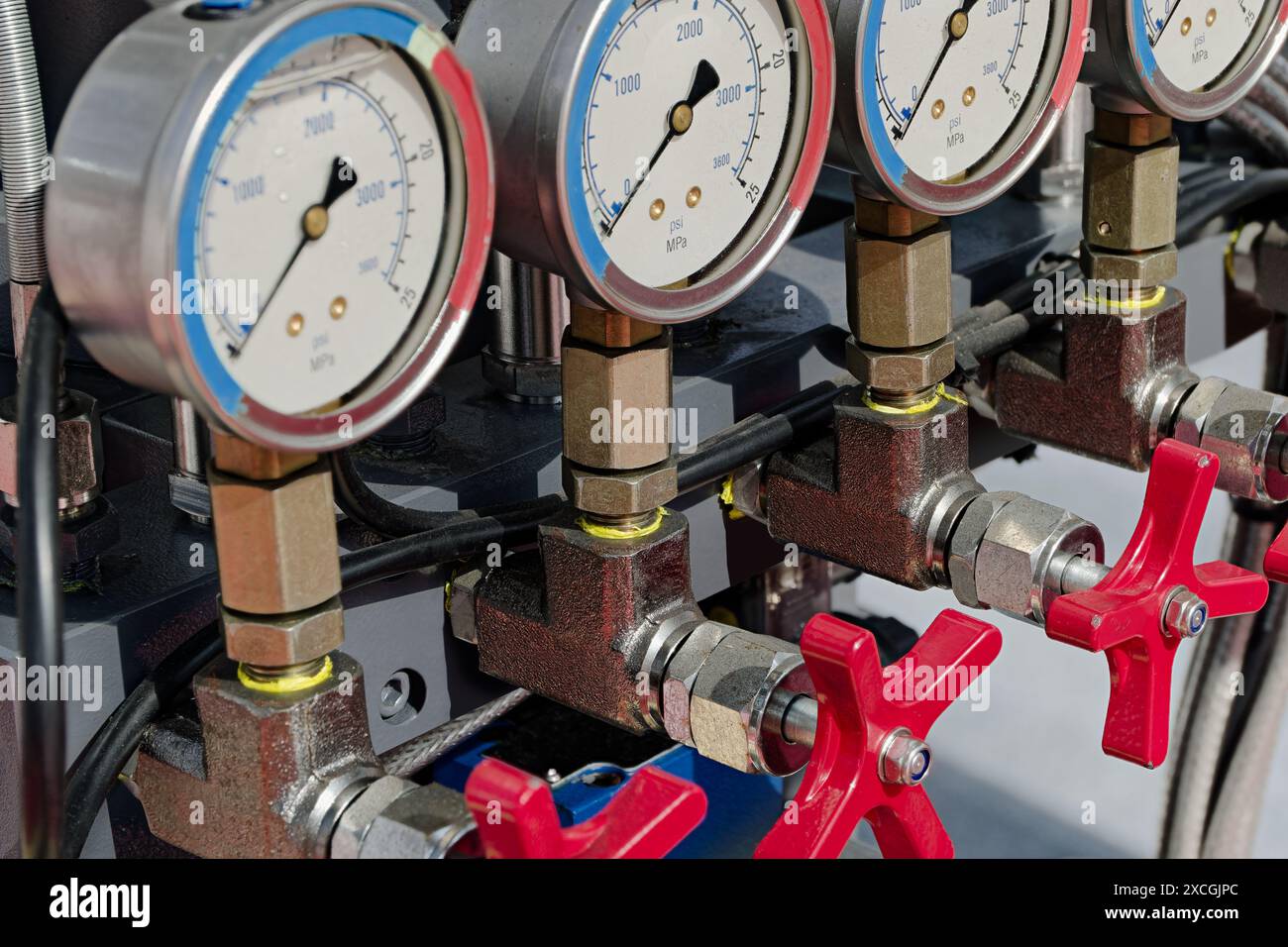 Commandes, manomètres et soupapes génériques du circuit hydraulique. Gros plan, fond industriel abstrait. Banque D'Images