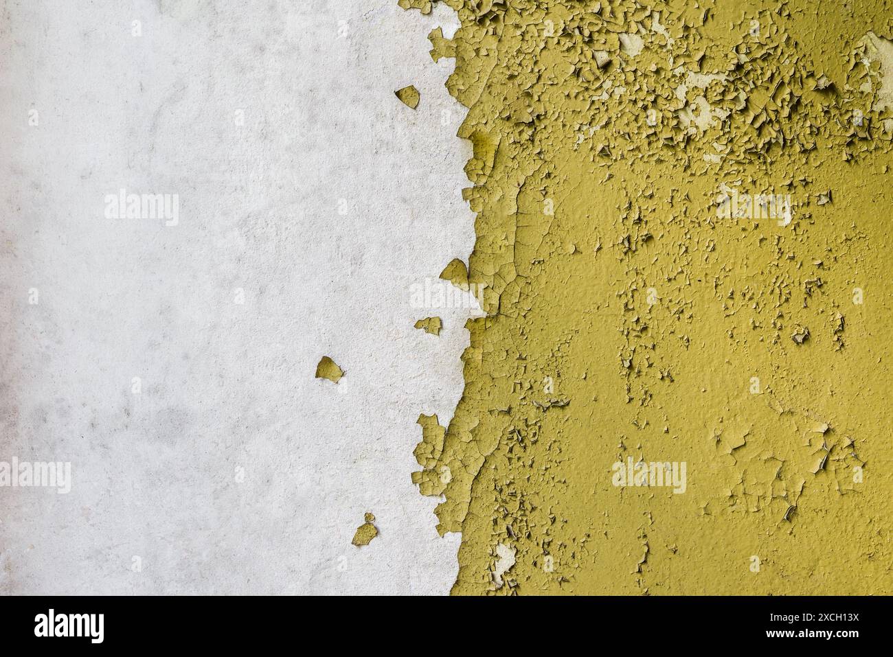 Texture d'un vieux mur de béton cassé avec peinture jaune pelable Banque D'Images