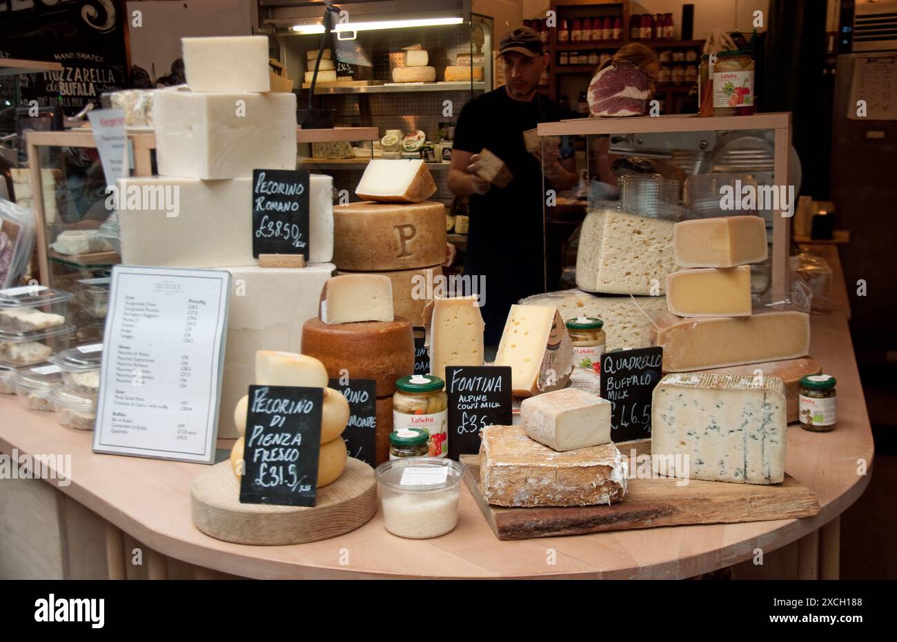 Kiosque à fromage, Borough Market, Bermondsey, Southwark, Londres, UK - fromages italiens et jambon en grandes quantités. Banque D'Images