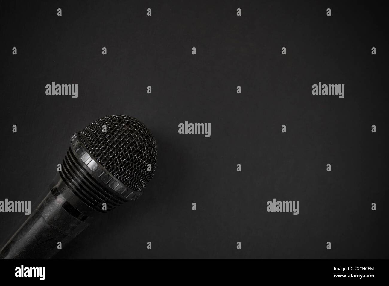 Microphone noir sur fond brumeux noir, gros plan flou, fond de podcast minimal Banque D'Images