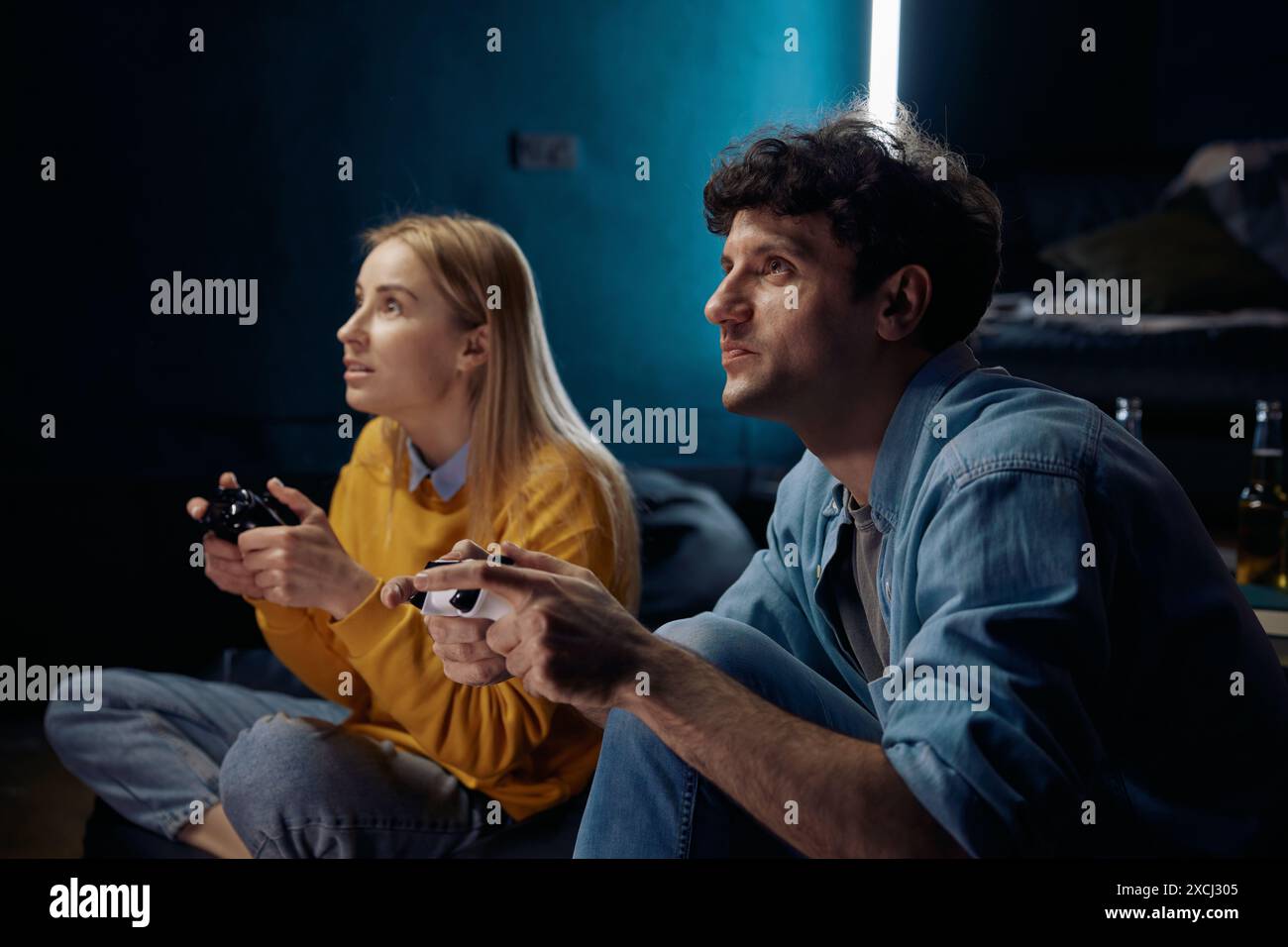 Femme et homme jouant à un jeu vidéo en utilisant des joysticks ensemble Banque D'Images