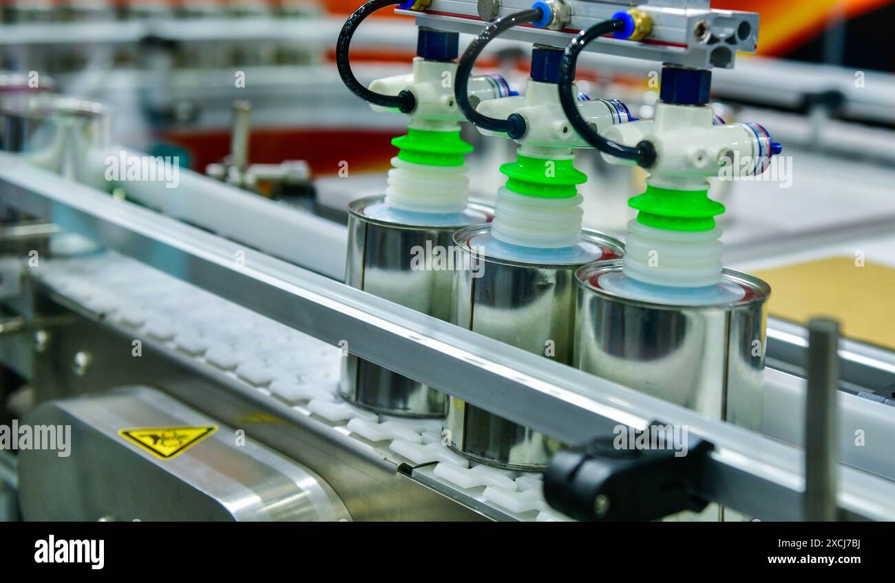 Produits alimentaires en conserve sur le tapis transporteur dans l'entrepôt de distribution. Concept du système de transport des colis Banque D'Images