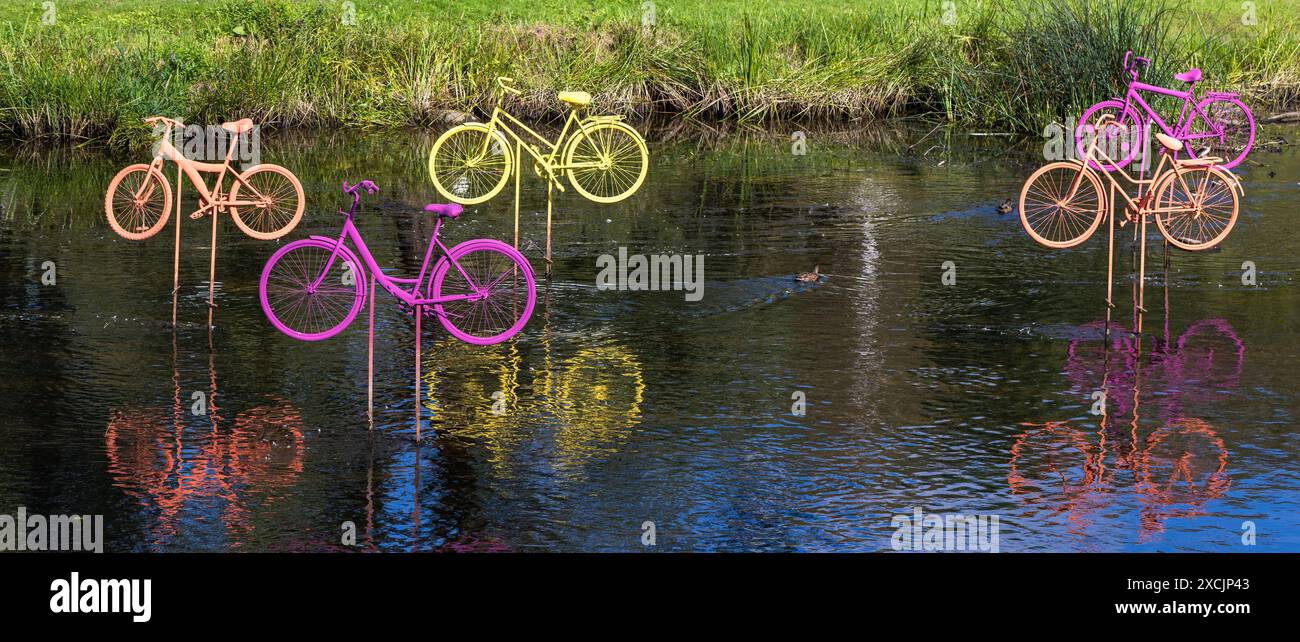 Installation sportive abstraite de vélos colorés dans l'eau par une journée d'été ensoleillée Banque D'Images