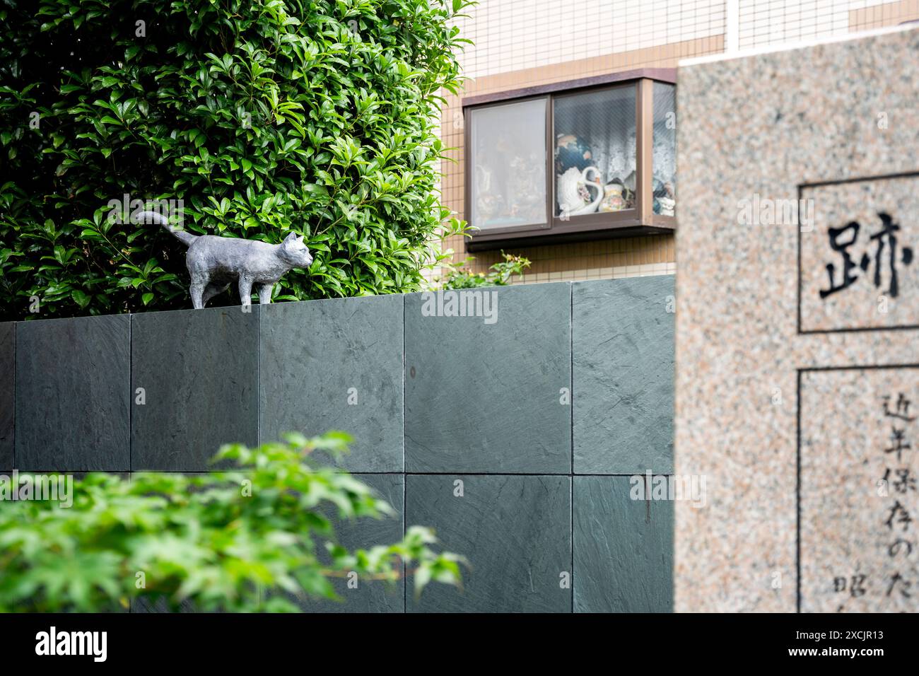 Statue d'un chat et pierre commémorative pointant l'endroit où l'écrivain japonais Natsume Soseki a vécu dans le quartier Bunkyo, Tokyo, Japon Banque D'Images