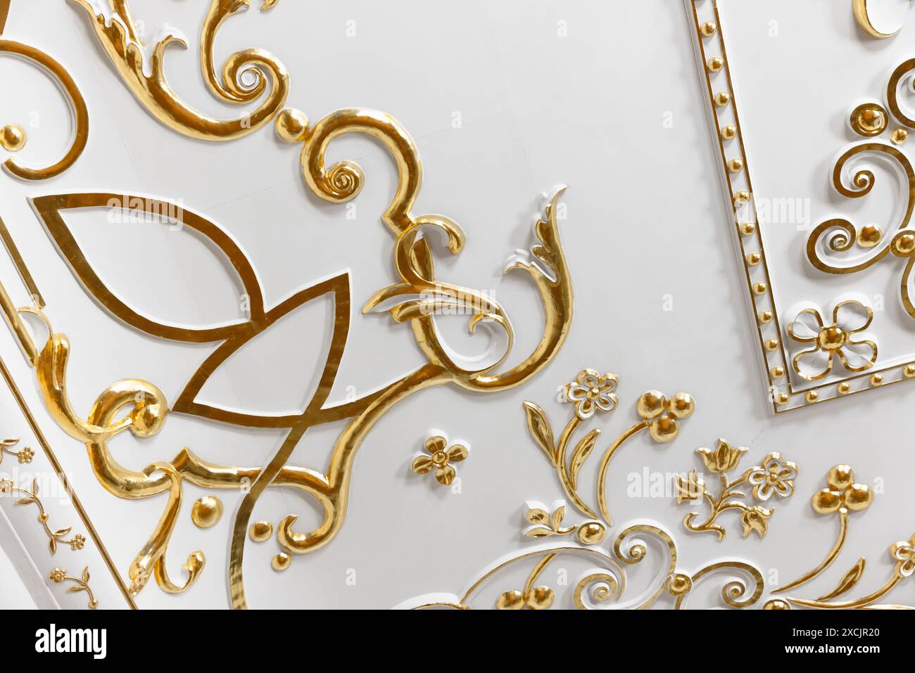 Fragment intérieur de luxe classique avec plafond blanc et mur décoré de détails dorés Banque D'Images