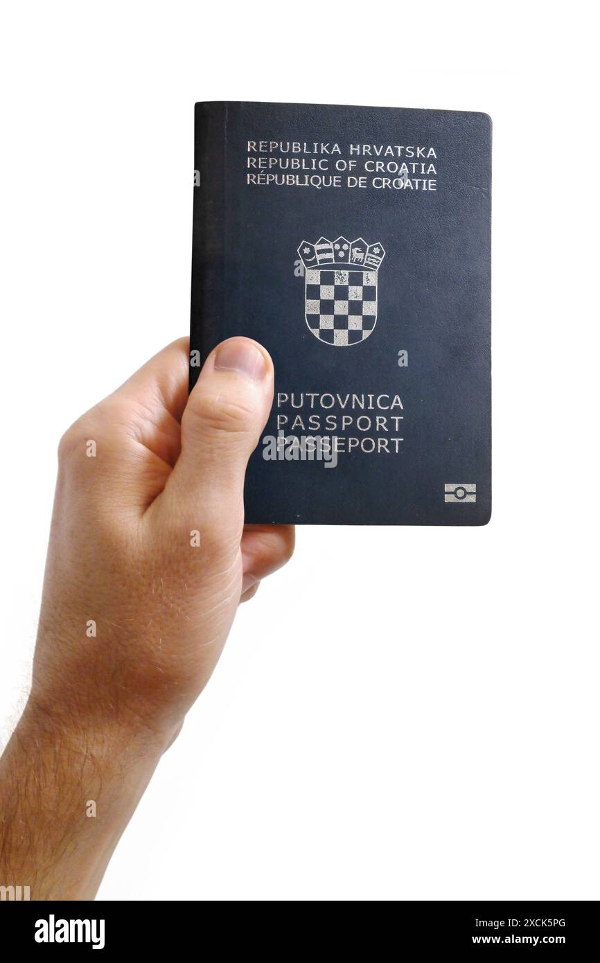 Gros plan sur la main d'un homme tenant un passeport de Croatie sur fond blanc. Banque D'Images
