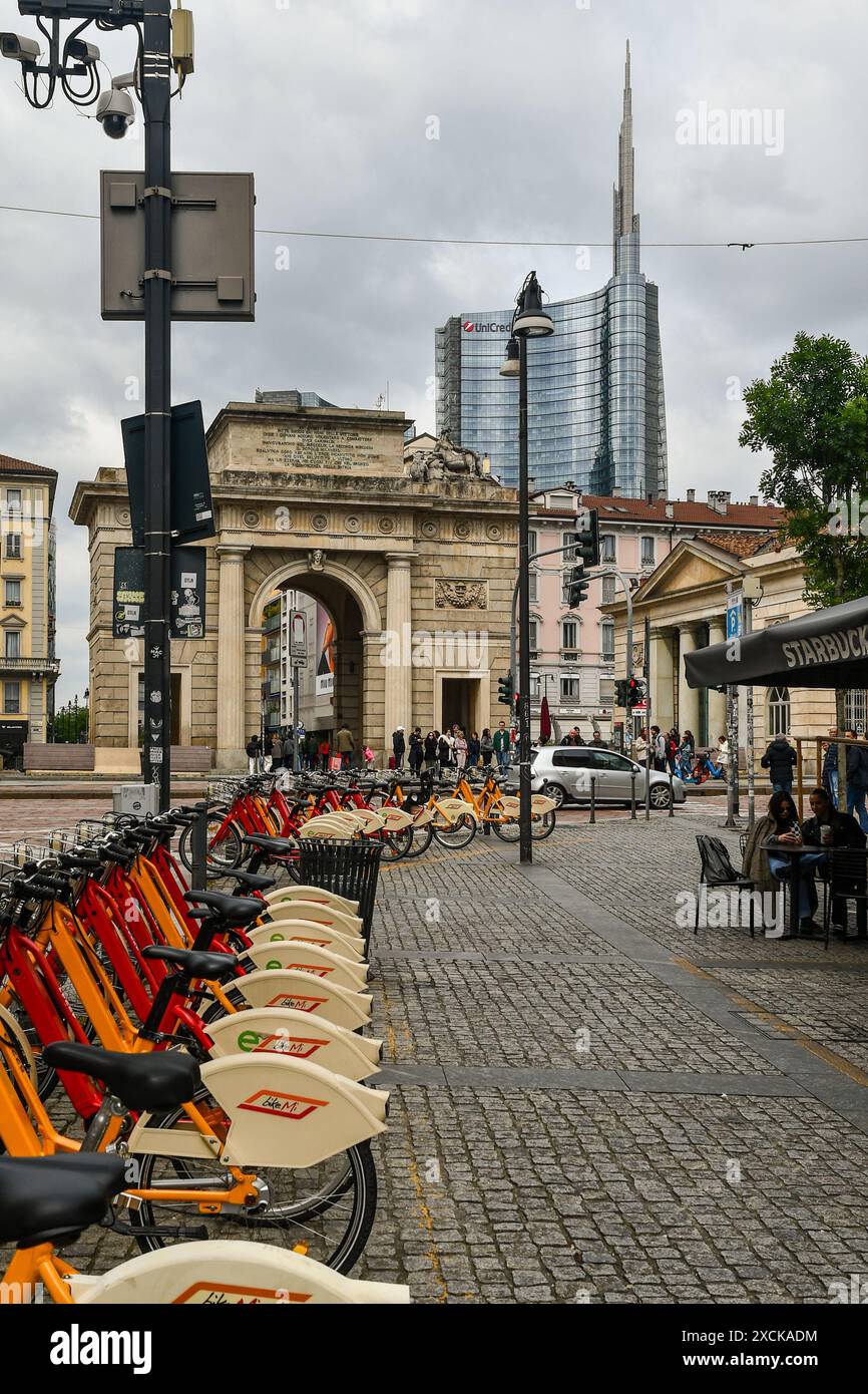 Rangée de vélos pour le partage de vélos avec l'ancienne porte de la ville Porta Garibaldi et la Torre UniCredit, le plus haut gratte-ciel d'Italie, Milan, Lombardie Banque D'Images