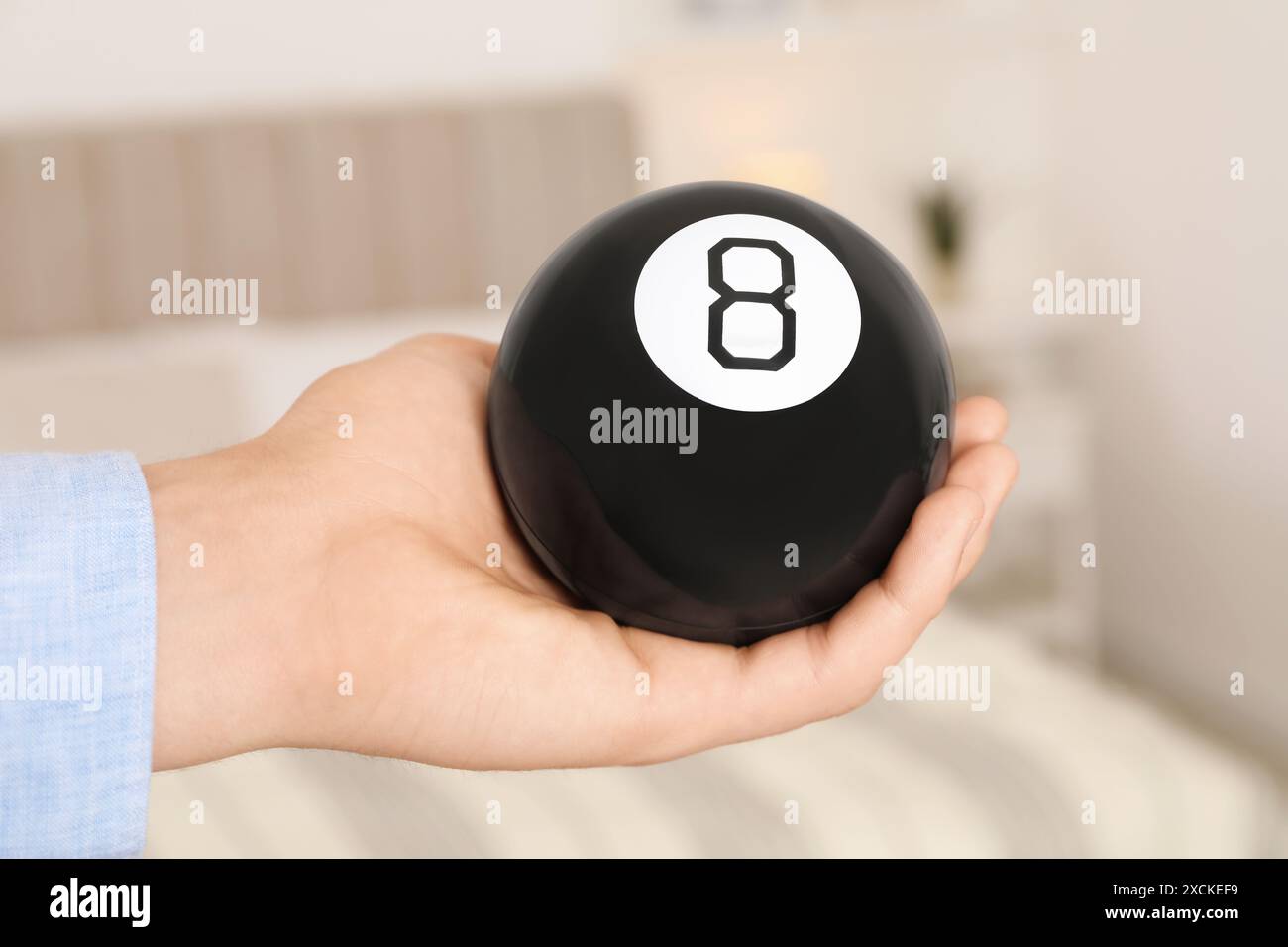 Homme tenant la boule magique huit à l'intérieur, gros plan Banque D'Images