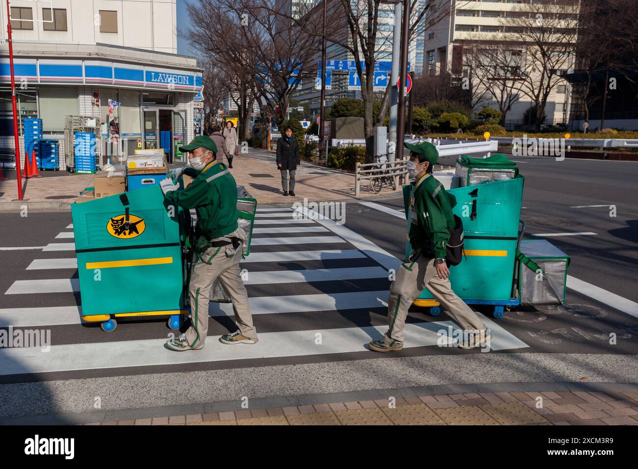 Deux chariots à roues hommes de livraison Yamato de compagnie de livraison dans la rue à Odaiba, Tokyo, Japon. Banque D'Images