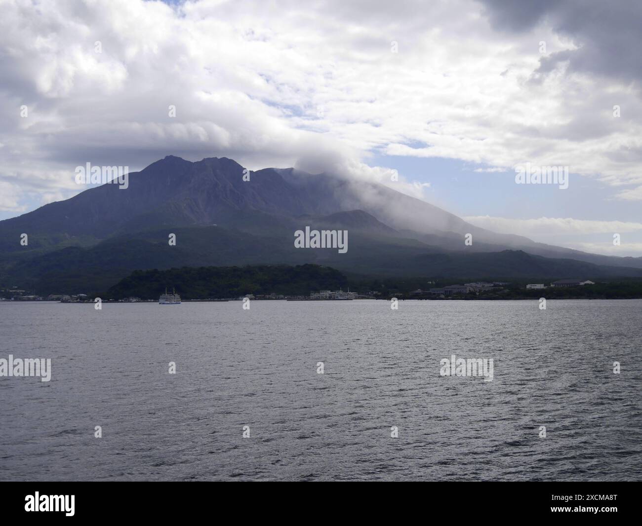 Île volcanique Sakurajima avec volcan fumant à Kyushu, Japon. Vue depuis la mer, près de Kagoshima. Volcan fumant et ciel nuageux Banque D'Images