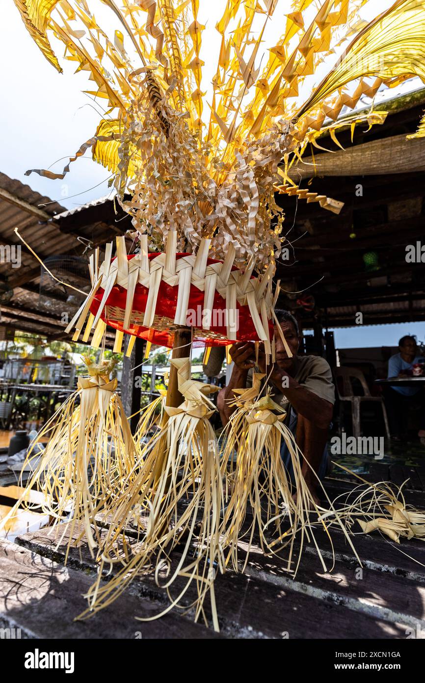 Un homme prépare des accessoires traditionnels pour le rituel Melanau serahang pendant le festival de Kaul Banque D'Images
