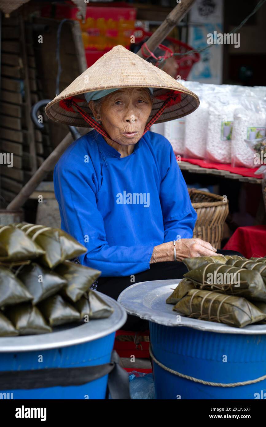 Femme âgée Hmong vendant de la nourriture au marché bac Ha, province de Lao Cai, Vietnam Banque D'Images