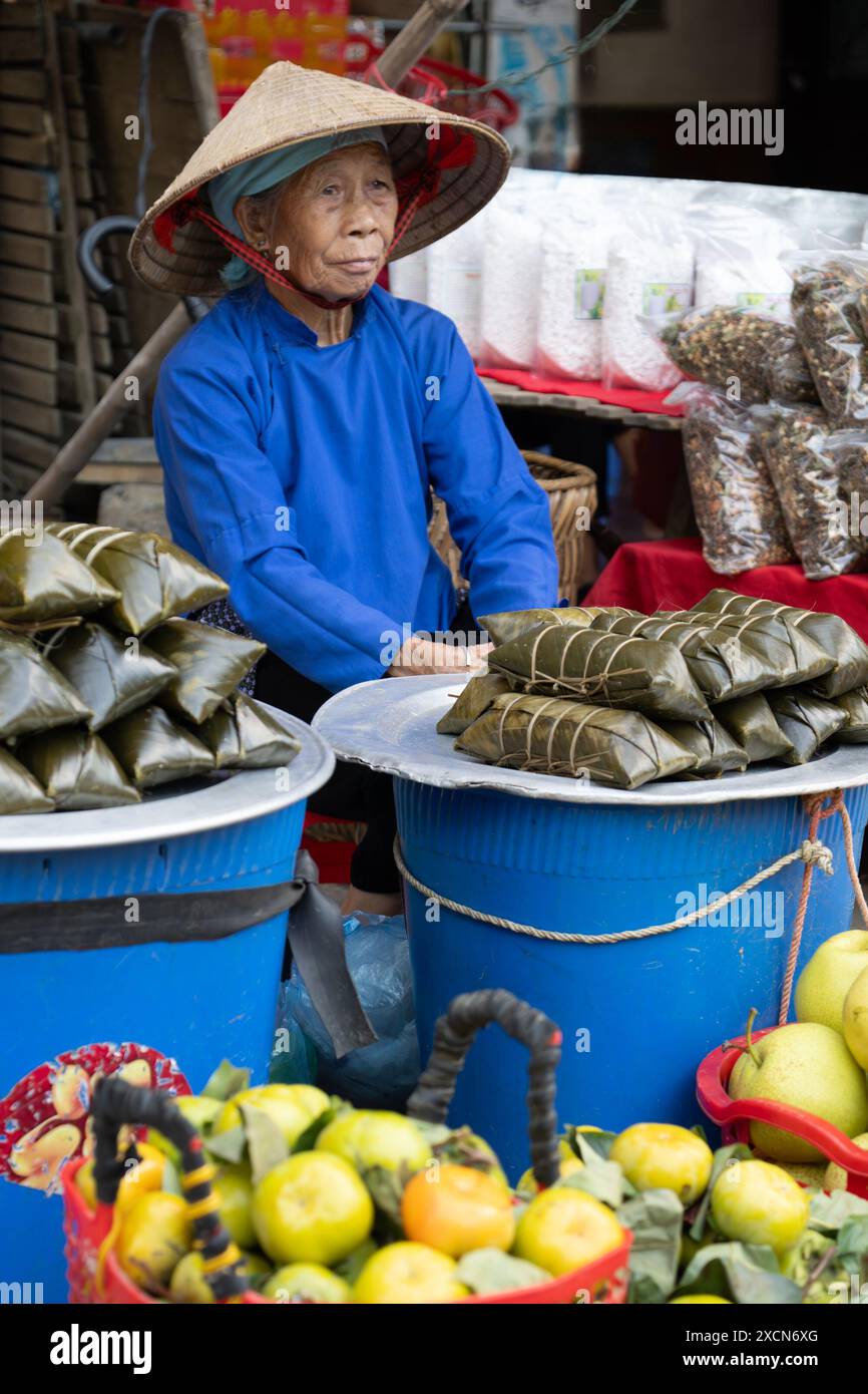 Femme âgée Hmong vendant de la nourriture au marché bac Ha, province de Lao Cai, Vietnam Banque D'Images