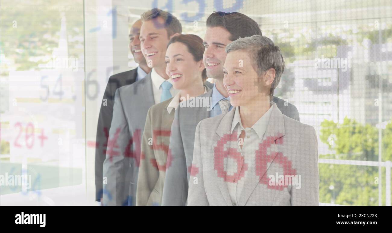 Image d'une table de négociation au-dessus de divers collègues souriants debout dans la rangée au bureau Banque D'Images