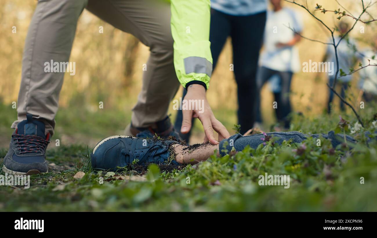 Groupe de sauveteurs trouvant une victime assassinée pieds nus dans la forêt, effrayé les gens appelant la police. Mystérieuse horreur homicide involontaire dans les bois, des civils ont trouvé un cadavre, un sombre meurtre. Caméra A. Banque D'Images