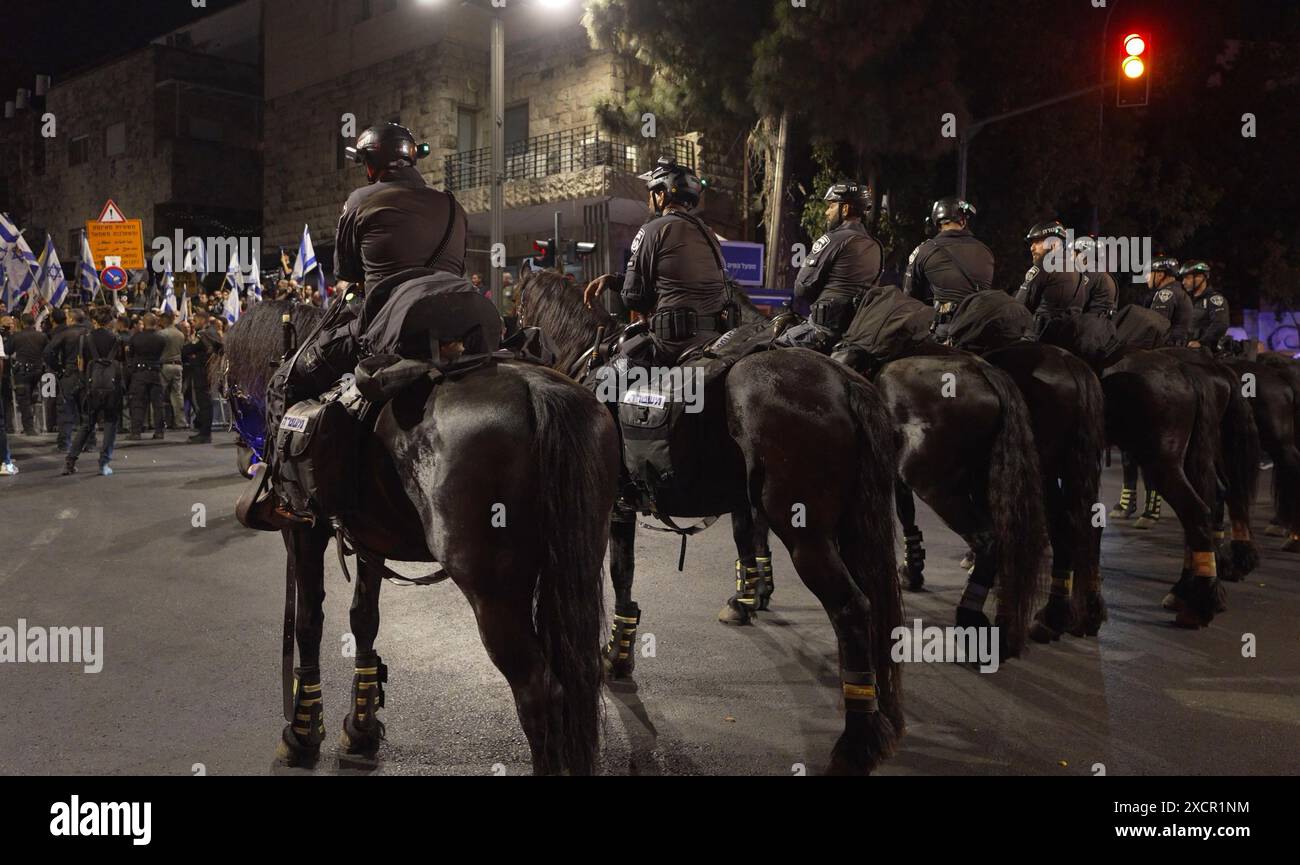 JÉRUSALEM - 17 JUIN : la police montée surveille les manifestants anti-gouvernementaux qui se rassemblent près de la résidence privée du premier ministre pour manifester contre le gouvernement de Netanyahou et appeler à de nouvelles élections le 17 juin 2024 à Jérusalem. Les frustrations des Israéliens envers le gouvernement dirigé par Benjamin Netanyahou ont persisté alors que plus de 100 otages restent captifs à Gaza, après près de huit mois de guerre entre Israël et le Hamas, le groupe militant palestinien qui a attaqué Israël le 7 octobre. Banque D'Images