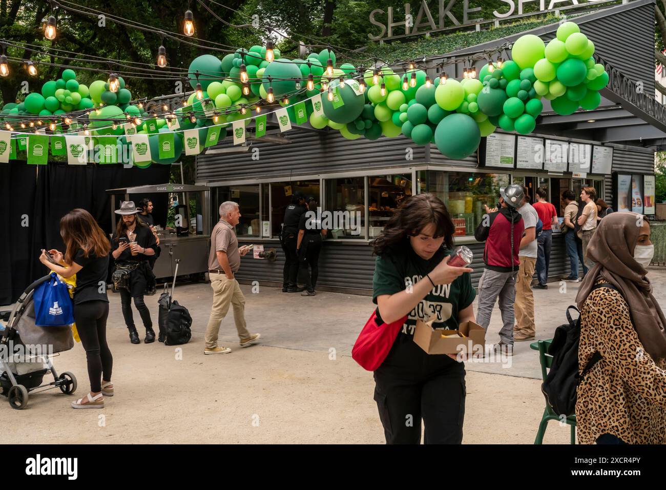 Les foules affluent au Madison Square Park à New York le mardi 11 juin 2024 pour célébrer le 20e anniversaire du populaire restaurant Shake Shack. Commencé par Danny Meyer comme un modeste chariot à hot dog, la société s'est développée en tant que concessionnaire dans le parc, puis a ouvert des succursales dans toute la ville et dans le monde entier. (© Richard B. Levine) Banque D'Images