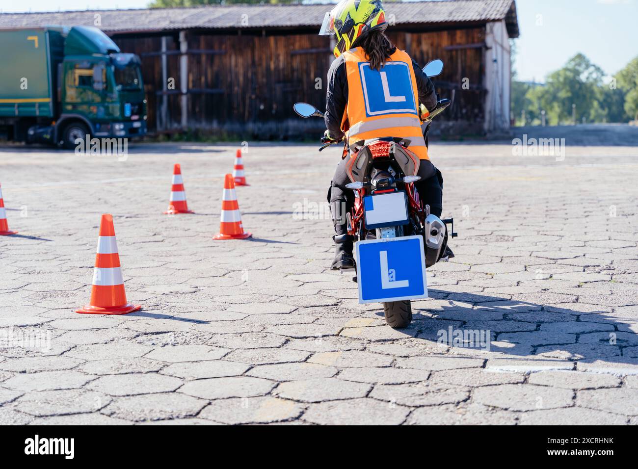 Un homme conduit une moto avec une plaque d'immatriculation bleue Banque D'Images