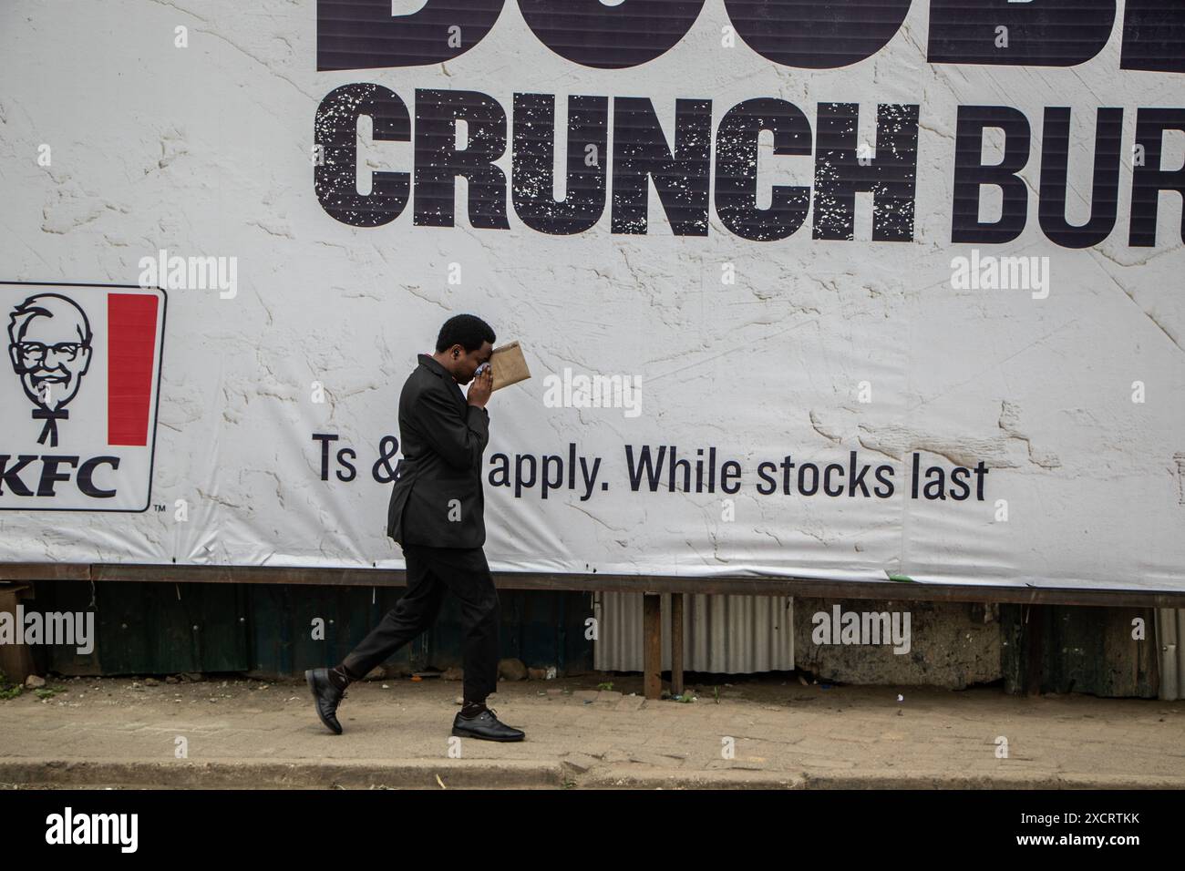 Nairobi, Kenya. 18 juin 2024. Un homme se protège des gaz lacrymogènes qui ont fait pression pour disperser les manifestants lors d'une manifestation contre le projet de loi de finances 2024 dans les rues de Nairobi. Le projet de loi propose plusieurs nouvelles taxes, dont une taxe de circulation sur les véhicules automobiles, une taxe sur les transferts de fonds, une taxe écologique et des droits d'accise sur le pain et l'huile de cuisson. La manifestation baptisée #RejectTheFinanceBill2024 a lieu alors que le projet de loi est déposé, avec des manifestants exhortant les membres du parlement à rejeter les dispositions litigieuses. Crédit : SOPA images Limited/Alamy Live News Banque D'Images