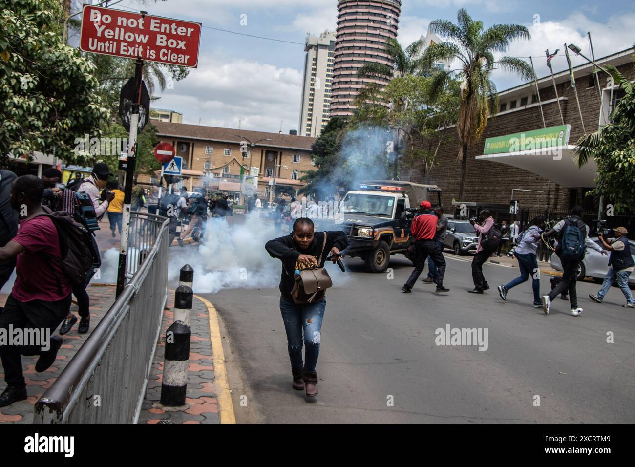 Nairobi, Kenya. 18 juin 2024. Une femme court pour la sécurité après que la police a fait pression sur des cartouches lacrymogènes pour disperser les manifestants lors d'une manifestation contre le projet de loi de finances 2024 dans les rues de Nairobi. Le projet de loi propose plusieurs nouvelles taxes, dont une taxe de circulation sur les véhicules automobiles, une taxe sur les transferts de fonds, une taxe écologique et des droits d'accise sur le pain et l'huile de cuisson. La manifestation baptisée #RejectTheFinanceBill2024 a lieu alors que le projet de loi est déposé, avec des manifestants exhortant les membres du parlement à rejeter les dispositions litigieuses. Crédit : SOPA images Limited/Alamy Live News Banque D'Images