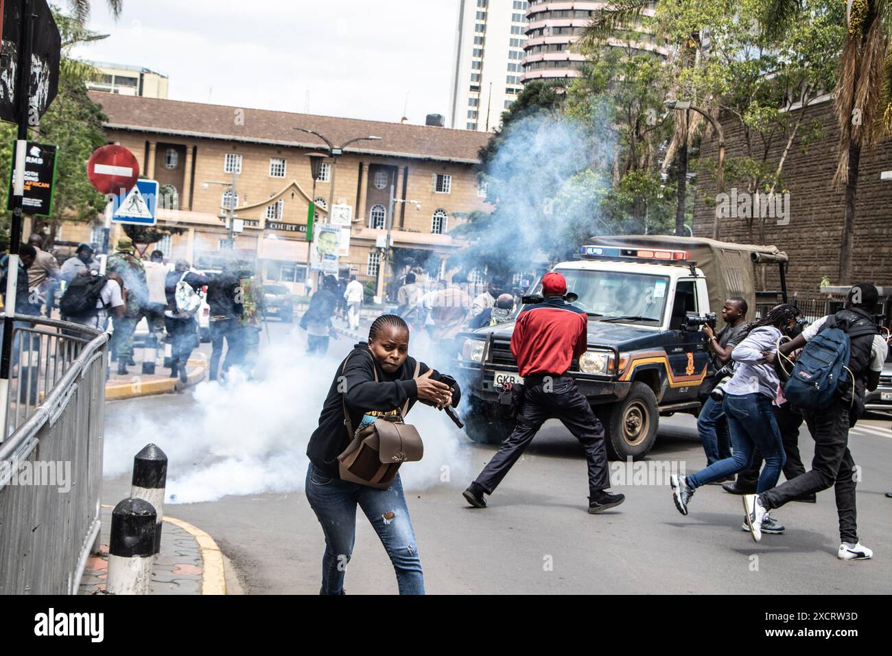 Nairobi, Kenya. 18 juin 2024. Une femme court pour la sécurité après que la police a fait pression sur des cartouches lacrymogènes pour disperser les manifestants lors d'une manifestation contre le projet de loi de finances 2024 dans les rues de Nairobi. Le projet de loi propose plusieurs nouvelles taxes, dont une taxe de circulation sur les véhicules automobiles, une taxe sur les transferts de fonds, une taxe écologique et des droits d'accise sur le pain et l'huile de cuisson. La manifestation baptisée #RejectTheFinanceBill2024 a lieu alors que le projet de loi est déposé, avec des manifestants exhortant les membres du parlement à rejeter les dispositions litigieuses. Crédit : SOPA images Limited/Alamy Live News Banque D'Images