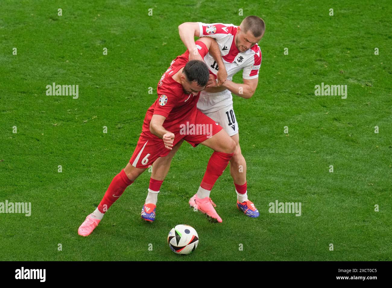 Turkey's Orkun Kokcu, left, challenges for the ball with Georgia's Giorgi Chakvetadze during a Group F match between Turkey and Georgia at the Euro 2024 soccer tournament in Dortmund, Germany, Tuesday, June 18, 2024. (AP Photo/Andreea Alexandru) Banque D'Images