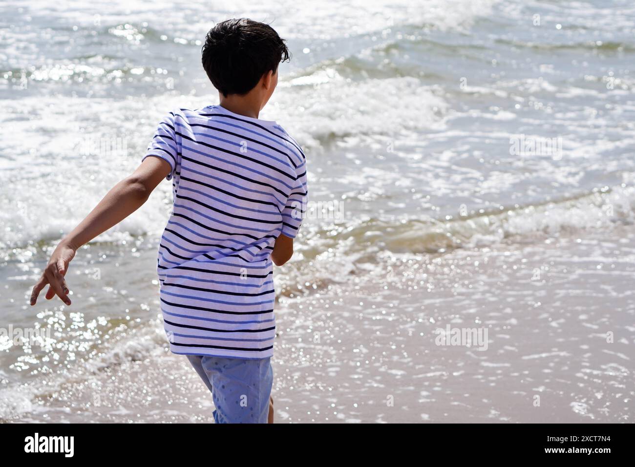 enfant courant le long du bord de mer en été Banque D'Images