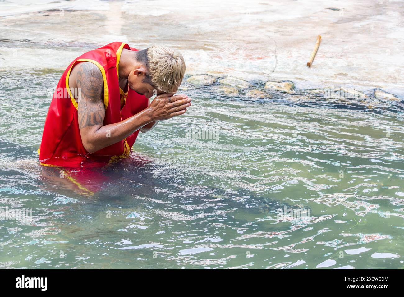 SAMUT PRAKAN, THAÏLANDE, MAI 26 2024, Tamer est assis sur un crocodile dans l'eau et prie avant de se produire Banque D'Images