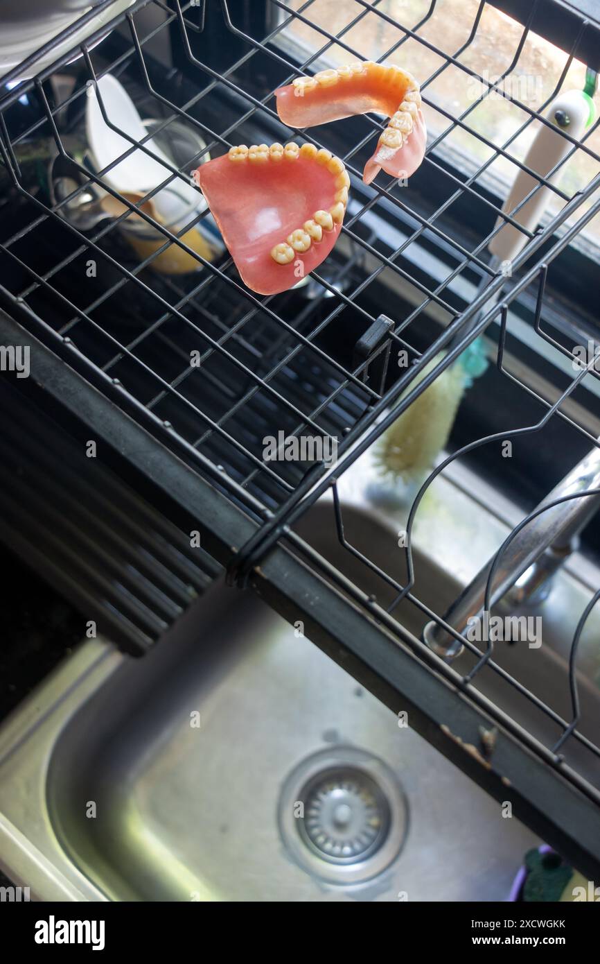 Les fausses dents usagées sèchent au-dessus de l'évier de cuisine Banque D'Images