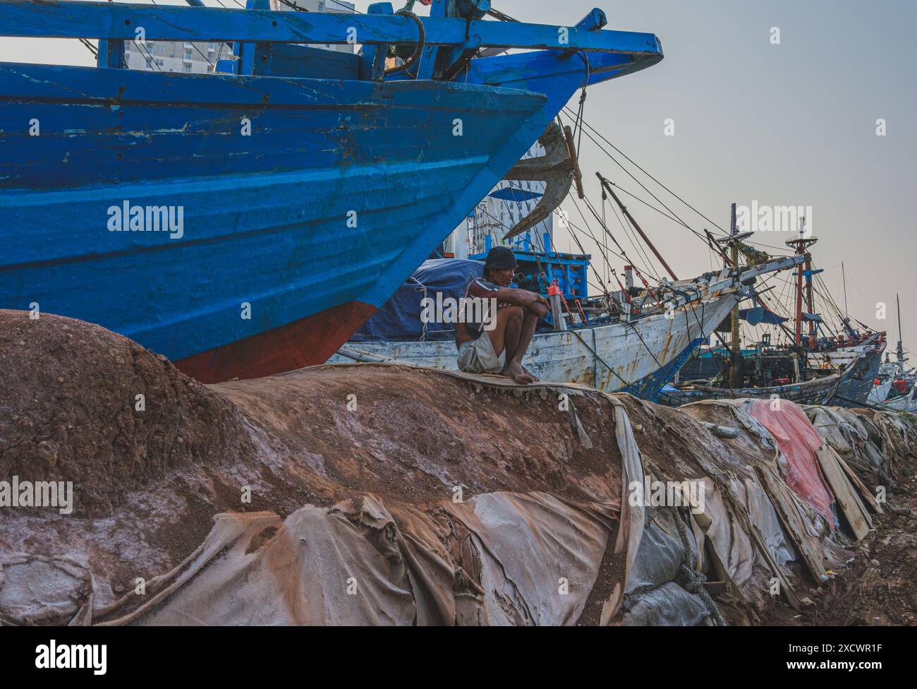 Jakarta, Indonésie - 9 mai 2024. Il est assis près de la goélette Phinisi à Sunda Kelapa. Harbor. Banque D'Images