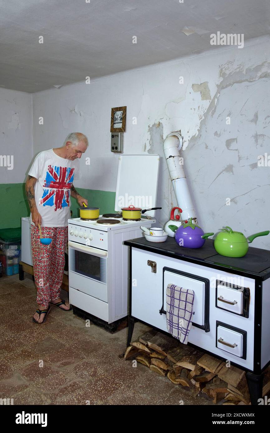 expatrié britannique masculin mature dans des vêtements appropriés repas de cuisine dans sa cuisine pour ses collègues expatriés zala comté hongrie Banque D'Images