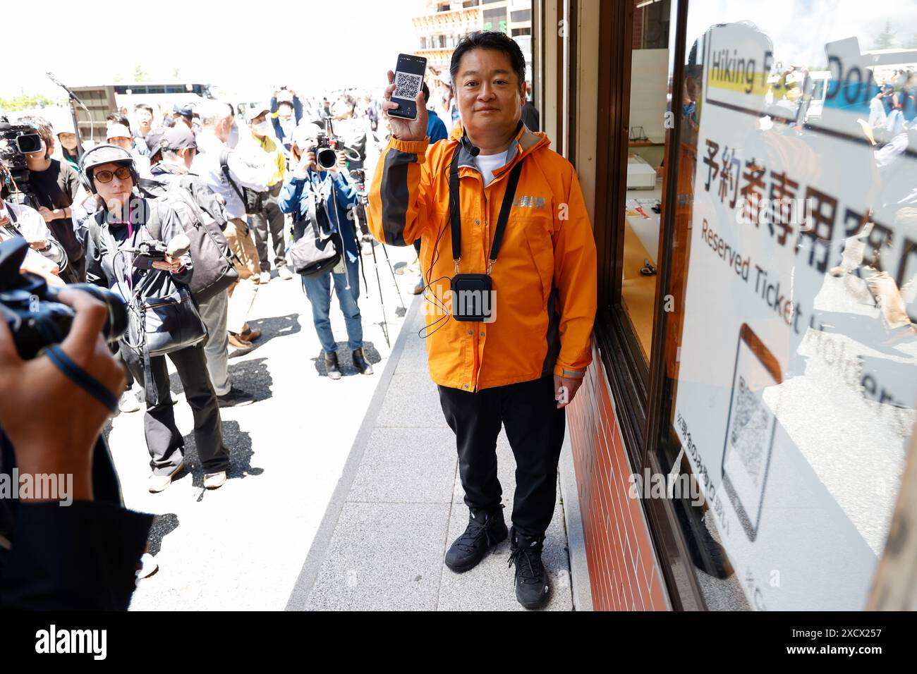 19 juin 2024, district de Minamitsuru, Yamanashi, Japon : Kotaro Nagasaki gouverneur de Yamanashi montre son code QR de réservation au 5e centre d'administration de la ligne Fuji Subaru, le point de départ le plus populaire pour gravir le mont Fuji. Le gouverneur Nagasaki a participé à une répétition en tant qu'alpiniste, montrant aux médias le fonctionnement actuel de la 5e station, y compris la collecte des droits d'entrée pour les grimpeurs. À partir de cette année, les autorités mettront en œuvre de nouvelles mesures telles qu’une limite de 4000 grimpeurs par jour, une augmentation des frais d’accès et un service à durée limitée. La saison de randonnée commence du 1er juillet à Septembe Banque D'Images