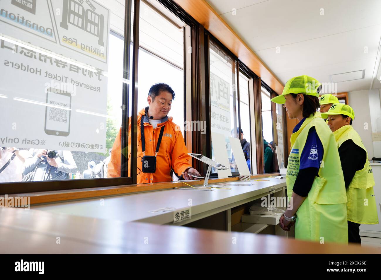 19 juin 2024, district de Minamitsuru, Yamanashi, Japon : Kotaro Nagasaki gouverneur de Yamanashi scanne son code QR de réservation au 5e centre d'administration de la ligne Fuji Subaru, le point de départ le plus populaire pour gravir le mont Fuji. Le gouverneur Nagasaki a participé à une répétition en tant qu'alpiniste, montrant aux médias le fonctionnement actuel de la 5e station, y compris la collecte des droits d'entrée pour les grimpeurs. À partir de cette année, les autorités mettront en œuvre de nouvelles mesures telles qu’une limite de 4000 grimpeurs par jour, une augmentation des frais d’accès et un service à durée limitée. La saison de randonnée commence du 1er juillet à Septembe Banque D'Images