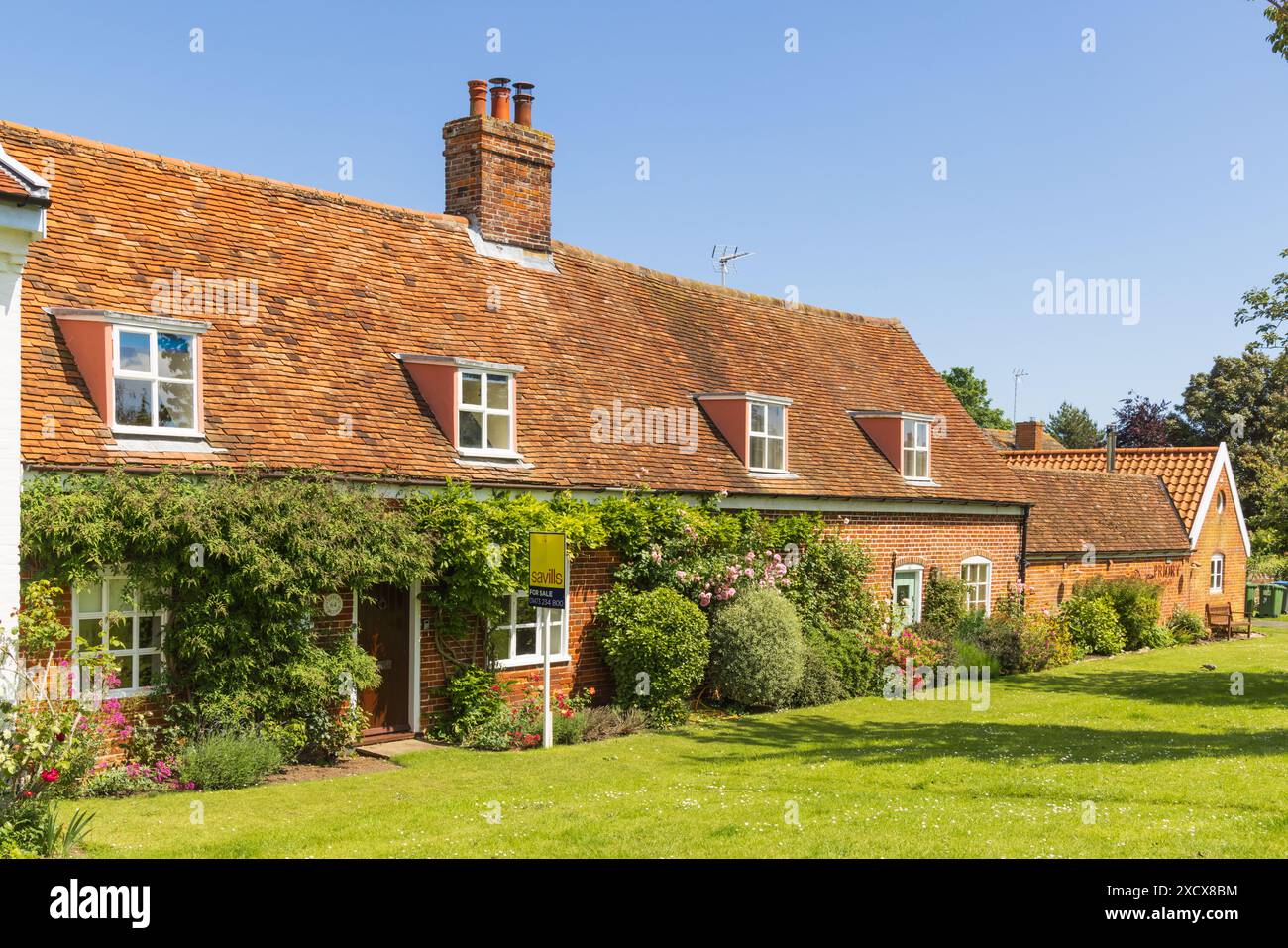Chalets de village anglais traditionnels, avec une maison Savills pour le signe de vente. Orford, Suffolk. ROYAUME-UNI Banque D'Images