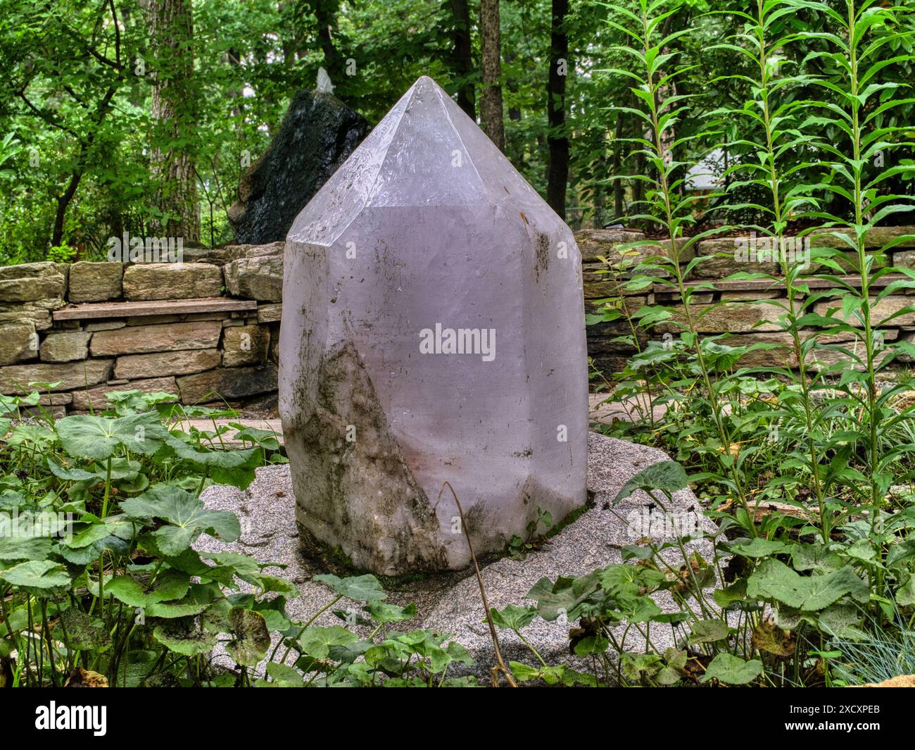 Une grande pierre de cristal de montagne dans un cadre de jardin Banque D'Images