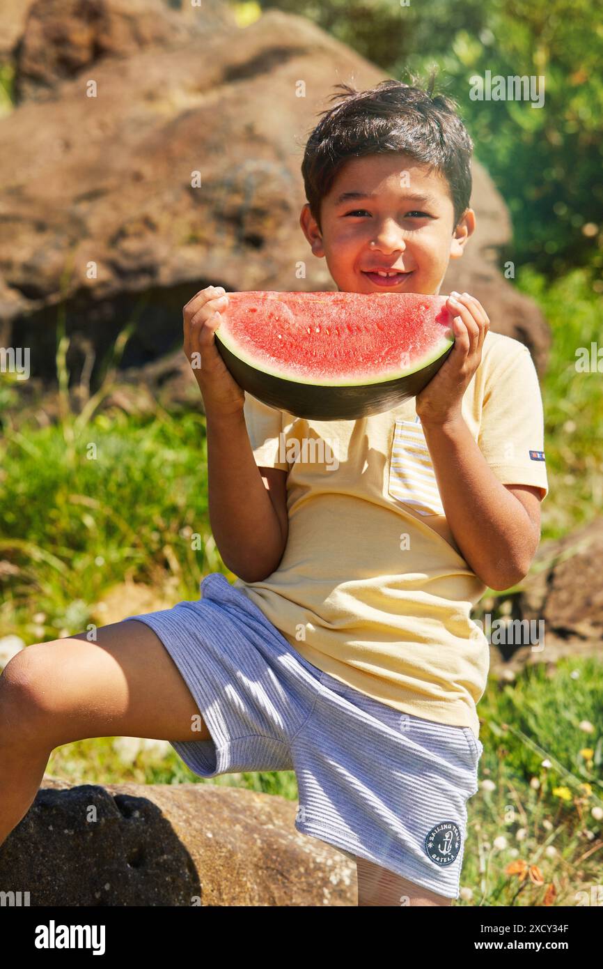 Enfant de 5-10 ans qui mange de la pastèque, Zumaia, Gipuzkoa, pays basque, Espagne Banque D'Images