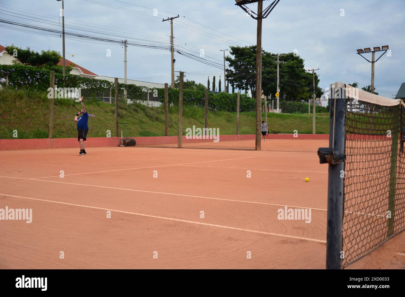 Joueur servant en compétition dans un jeu de tennis Banque D'Images