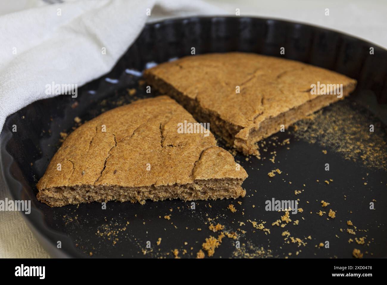 Photographie rapprochée de tranches restantes d'orge estonien traditionnel (Odrakarask) dans une forme de cuisson en céramique noire avec un torchon blanc Banque D'Images
