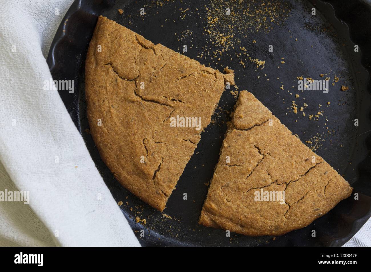 Photographie de table du traditionnel Scone d'orge estonien (Odrakarask) tranches restantes dans une forme de cuisson en céramique noire avec une serviette de cuisine blanche Banque D'Images