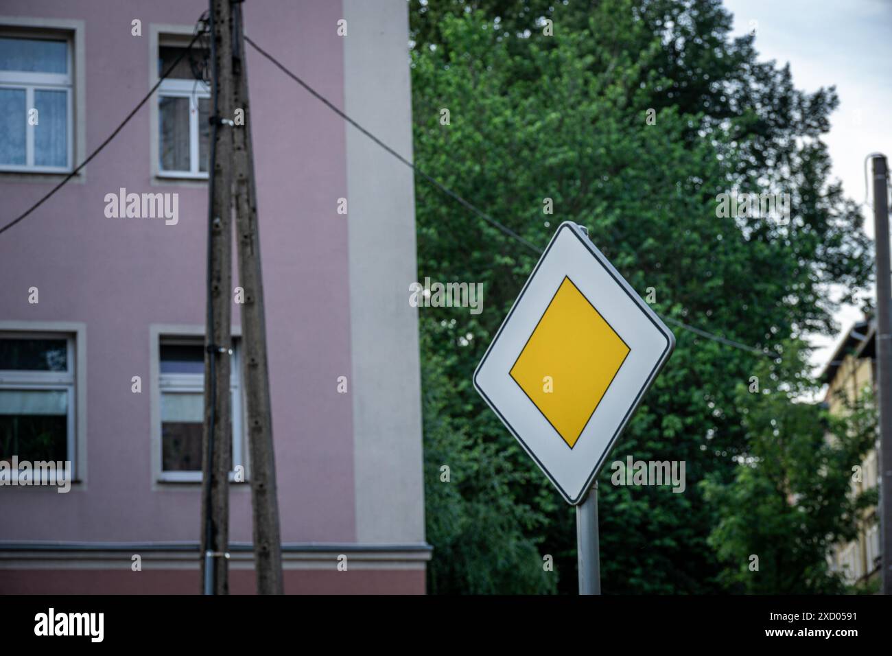 Panneau routier prioritaire devant le bâtiment un jour ensoleillé Banque D'Images