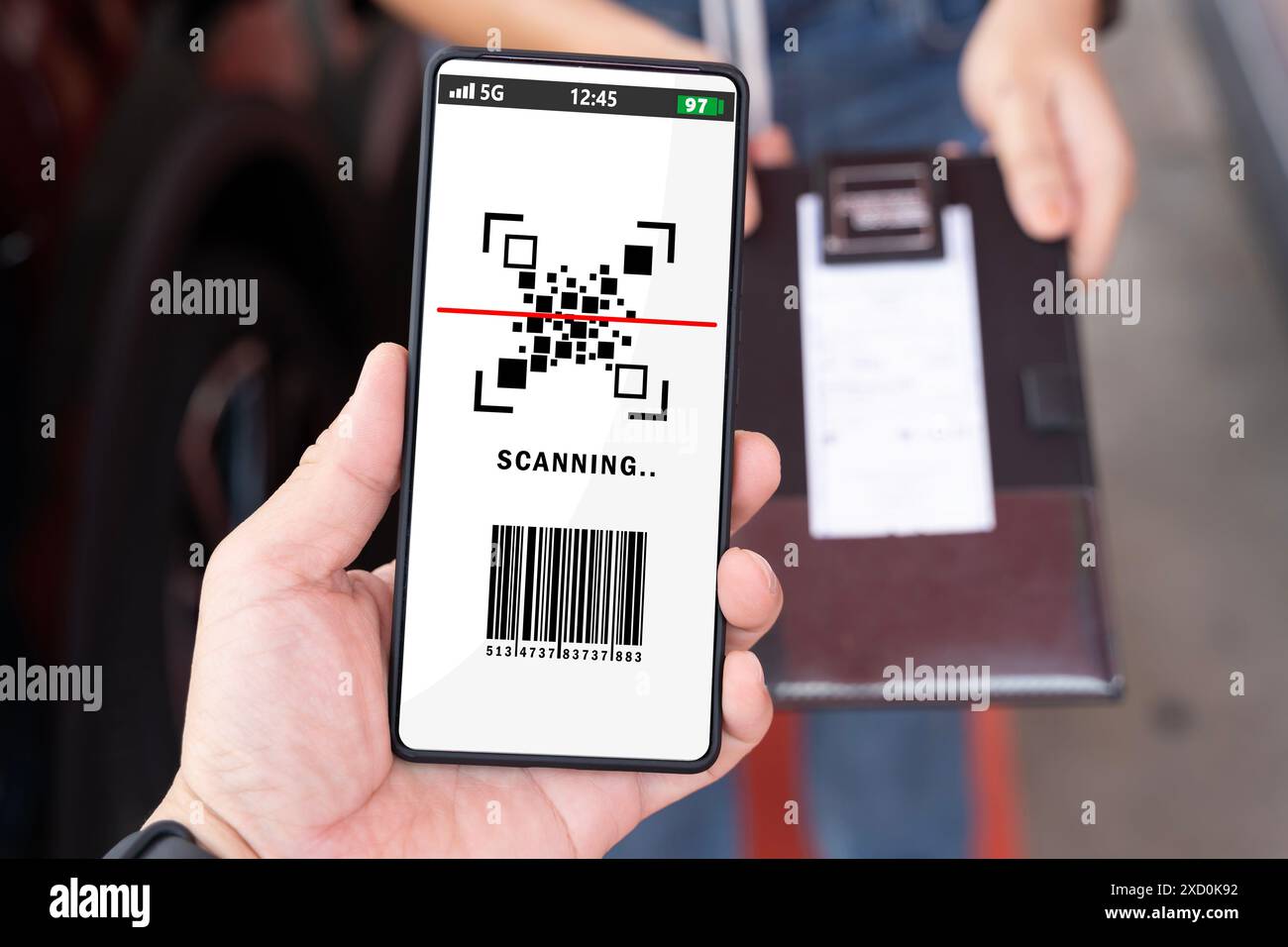 Une personne tient un téléphone qui dit « numérisation » dessus. Ils tiennent également un reçu, main féminine tenant un téléphone portable noir avec code qr sur le SC Banque D'Images