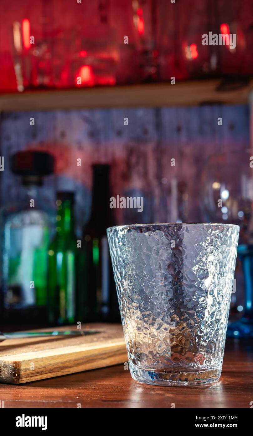 Verre dans le bar d'un bar, dans les verres de fond et des bouteilles avec des lumières colorées. Cocktails, rhum, vodka, ambiance nocturne, fête et fraîcheur. JO Banque D'Images