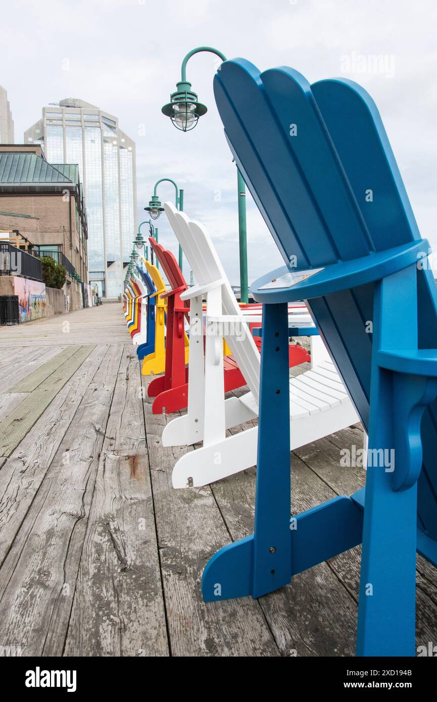 Rangée de chaises Adirondack colorées sur la promenade riveraine à Halifax, Nouvelle-Écosse, Canada Banque D'Images