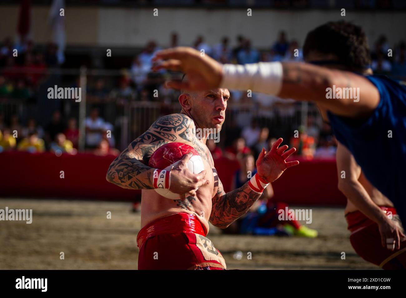 FLORENCE, ITALIE, 15 JUIN finale entre Rossi de Santa Maria Novella et Blue Azzurri de Santa Croce. – Le joueur de l’équipe rouge esquive un rival. Le Calcio Storico Fiorentino (football historique de Florence), également connu sous le nom de Calcio in costume (football costumé), est un jeu d'équipe avec un ballon qui a des origines éloignées et est aujourd'hui l'une des plus anciennes traditions florentines. Les jeux sont précédés par une procession de Piazza Santa Maria Novella à Piazza Santa Croce, où le terrain de jeu est aménagé. Le jeu de Calcio Storico Fiorentino est un défi entre les quatre quartiers de la ville. Les matchs sont joués i. Banque D'Images