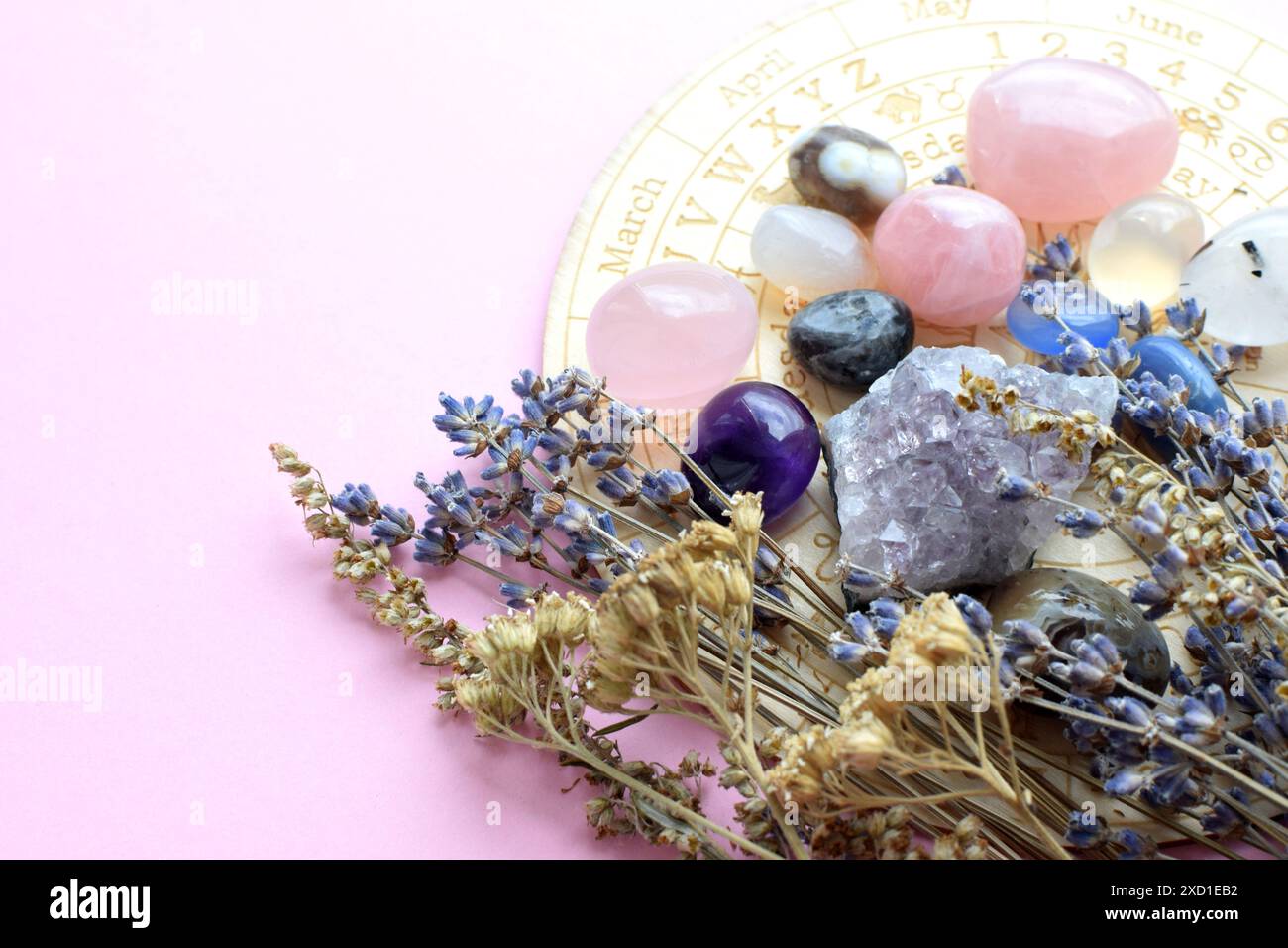 Beaux cristaux d'améthyste et herbes sèches sur fond rose avec des symboles des signes du zodiaque. Prédictions, sorcellerie, pratique ésotérique spirituelle. Banque D'Images