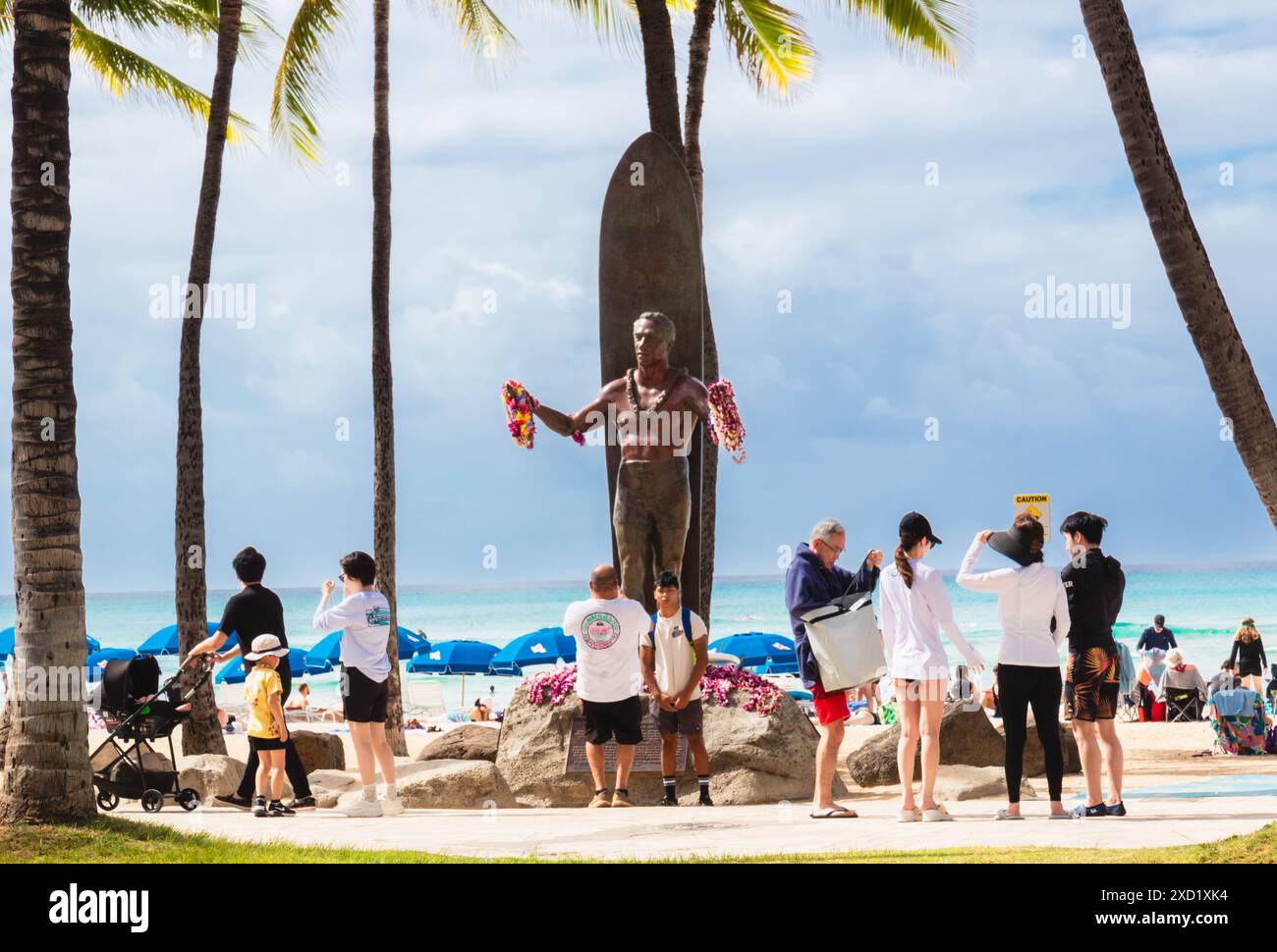 Touristes se rassemblant autour de la statue du duc Paoa Kahanamoku prenant des photos à Waikiki Beach. Banque D'Images