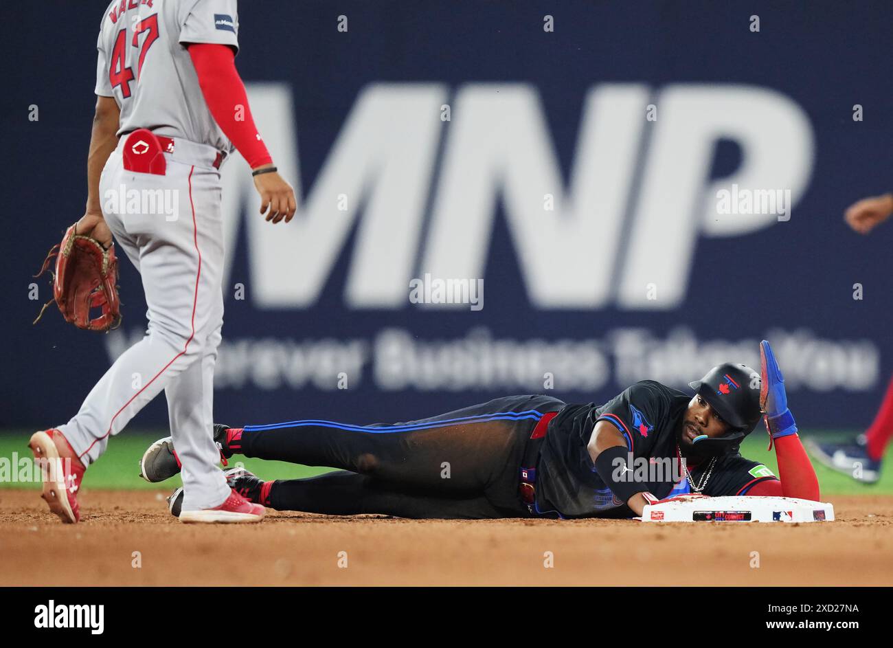Toronto, Canada. 19 juin 2024. Vladimir Guerrero Jr. (27), premier joueur des Blue Jays de Toronto, repose sur le sol à la deuxième base alors que Enmanuel Valdez (47), deuxième joueur des Boston Red Sox, regarde lors de la septième manche de baseball de la Ligue américaine MLB à Toronto le mercredi 19 juin 2024. Crédit : la presse canadienne/Alamy Live News Banque D'Images