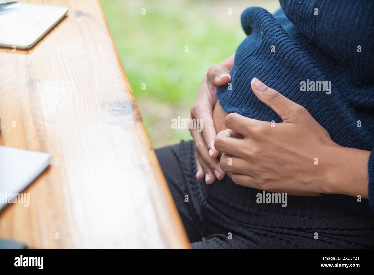 la mère enceinte utilise ses mains pour toucher son estomac pour réconforter bébé à l'intérieur de l'utérus avec tendresse et amour pour le bébé. Une future mère utilise son ha Banque D'Images