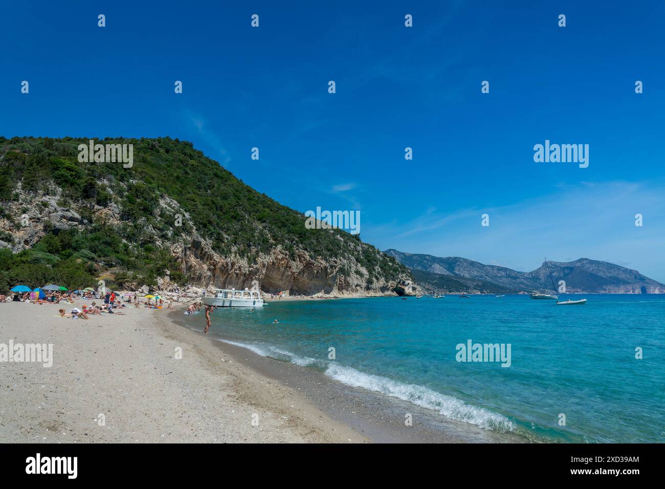 Les gens et les bateaux à la plage de Cala Luna et l'eau bleue transparente claire dans le golfe d'Orosei, île de Sardaigne, Italie Banque D'Images