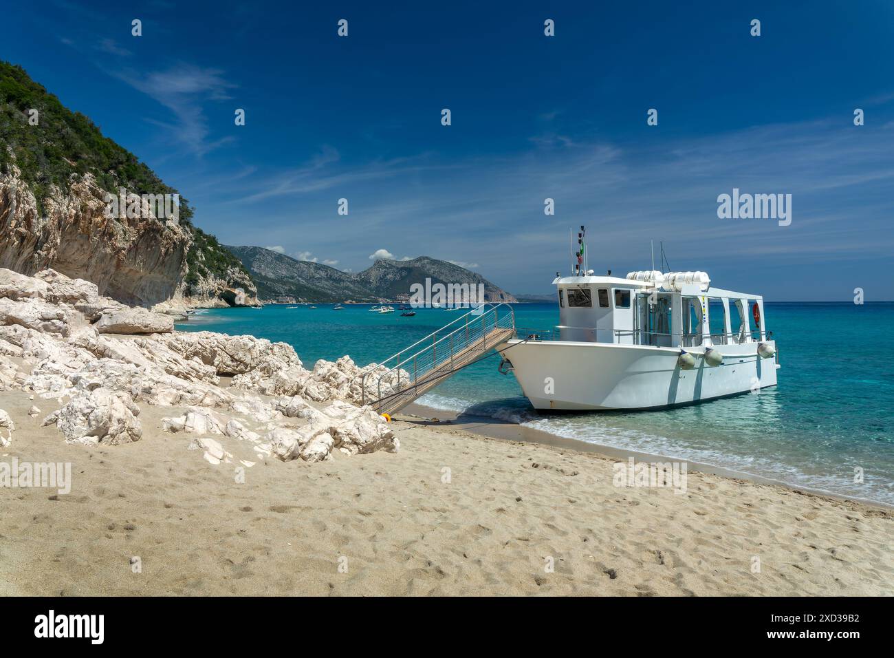Bateau de croisière touristique à la plage de Cala Luna et eau bleue transparente claire dans le golfe d'Orosei, île de Sardaigne, Italie Banque D'Images